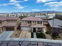 Aerial view of a tan two-story home with a tile roof in a neighborhood with mountain views at 9604 Vital Crest St, Las Vegas, NV 89123