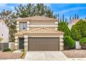 Two-story home showcasing a tile roof, neutral stucco exterior, and attached two-car garage at 10009 Coral Sands Dr, Las Vegas, NV 89117