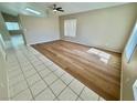 Open-concept living room with durable wood and tile flooring with many windows bringing in natural light at 10025 Catseye Cove Ct, Las Vegas, NV 89183