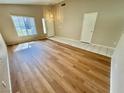 Bright living room with wood-look flooring, tile entryway, and a large picture window at 10025 Catseye Cove Ct, Las Vegas, NV 89183