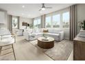 Bright, open-concept living room featuring hardwood floors, large windows, and a comfortable seating arrangement at 10029 Luna River Ave, Las Vegas, NV 89148