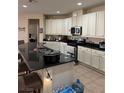 This spacious kitchen features modern appliances, granite counters, and bar stool seating at the counter at 10590 Natural Bridge St, Las Vegas, NV 89179