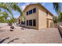 Expansive backyard featuring a patio, desert landscaping, and mature palm trees at 1421 Via Savona Dr, Henderson, NV 89052