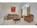 Cozy living room with a large window, comfortable seating, and decorative artwork on the walls at 1421 Via Savona Dr, Henderson, NV 89052
