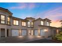 Stunning stucco home featuring a four-car garage, upper-level balconies, and manicured landscaping for added curb appeal at 20 Via Visione # 105, Henderson, NV 89011