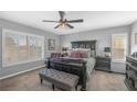 Comfortable bedroom features carpet floors, fan, plantation shutters, a large comfortable bed, and modern furniture at 2021 Royal Gardens Pl, North Las Vegas, NV 89084
