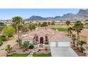 Landscaped front yard with palm trees enhances this charming desert home with a red tile roof and two-car garage at 2257 Lauren Dr, Las Vegas, NV 89134