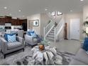 Spacious living room with modern decor, an open staircase, and a glimpse into the kitchen at 2501 Rofrano Pl, Henderson, NV 89044