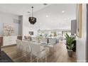 Elegant dining area with a glass-top table, modern chairs, and an open view of the living space at 2620 E Harmon Ave, Las Vegas, NV 89121