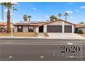 Ranch-style home with desert landscaping, solar panels, a two-car garage, and a well-maintained lawn at 2620 E Harmon Ave, Las Vegas, NV 89121