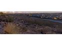 Expansive city view at twilight over a hillside with natural desert vegetation and homes below at 2650 Skylark Trail St, Henderson, NV 89044