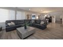 Spacious living room with modern furniture, light gray walls, plank floors and an open concept design at 2650 Skylark Trail St, Henderson, NV 89044