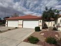 Attractive single-story home with a red tile roof, two-car garage, and well-maintained landscaping at 2679 Magic Moon Ln, Las Vegas, NV 89146