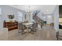 Elegant dining room with stylish lighting, seating for six, and staircase access to upper level at 3171 Biccari Ave, Henderson, NV 89044