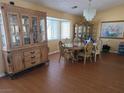 Elegant dining room with wood floors, chandelier, and a large china cabinet at 3261 Winery Rd, Pahrump, NV 89048