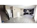 Open concept living room showcasing tile floors, recessed lighting, stairs and seamless flow into the kitchen at 3707 Paseo De Paz Ave, Las Vegas, NV 89115