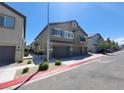 Street view of a two-story townhouse with a three-car garage and balcony on the second level at 4645 Fuchsia Nights Ave # 103, North Las Vegas, NV 89084