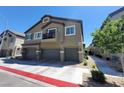 Two-story townhouse featuring a three-car garage, balcony, and well-maintained landscaping at 4645 Fuchsia Nights Ave # 103, North Las Vegas, NV 89084
