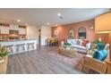 Open-concept living area with kitchen, dining, and stylish furniture, wood floors, and neutral tones at 4839 Orchid Ridge Ave # 96, Las Vegas, NV 89141