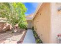 Inviting front entrance with a cozy walkway surrounded by lush greenery and flowers at 5017 Hadley Meadow Ct, Las Vegas, NV 89131