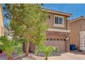 Attractive two-story residence featuring a stone-detailed garage, neat desert landscaping, and a welcoming facade at 5239 Tartan Hill Ave, Las Vegas, NV 89141