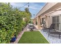 Inviting outdoor space featuring a covered patio, dining set, and manicured lawn with mature landscaping at 53 Grossinger Ct, Henderson, NV 89074