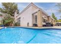 Backyard pool featuring a covered patio with lounge furniture and a manicured lawn at 53 Grossinger Ct, Henderson, NV 89074