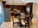 Open-concept kitchen with dark wood cabinetry, stainless steel appliances, and a breakfast nook with a round table at 530 Calahonda Ct, Las Vegas, NV 89138