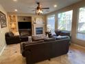 Comfortable living room with a ceiling fan, fireplace and large windows allowing for ample natural light at 530 Calahonda Ct, Las Vegas, NV 89138
