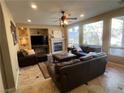 Inviting living room featuring large windows, a fireplace, and comfortable seating with plush leather furniture at 530 Calahonda Ct, Las Vegas, NV 89138