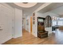 Elegant home foyer featuring wood floors, a decorative bench, and an open floor plan at 7349 Royal Melbourne Dr, Las Vegas, NV 89131