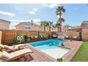 Backyard pool features palm trees, patio furniture, and a lush outdoor space for relaxation and entertainment at 7566 Hope Valley St, Las Vegas, NV 89139