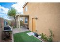 Relaxing backyard with a covered patio, artificial turf, and convenient access door to the house at 8368 Creek Canyon Ave, Las Vegas, NV 89113