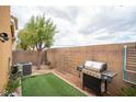 Cozy backyard featuring a well-placed grill, artificial turf, and block wall ensuring privacy at 8368 Creek Canyon Ave, Las Vegas, NV 89113