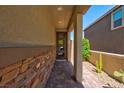 Inviting entryway with stone accent wall, brick pathway, and stylish front door with glass panels at 880 Cirrus Cloud Ave, Las Vegas, NV 89138