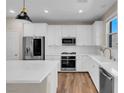 Modern kitchen with white cabinets, stainless steel appliances, quartz countertops, and stylish pendant lighting at 880 Cirrus Cloud Ave, Las Vegas, NV 89138