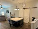 Dining area with a large table, slider door, and barn doors, perfect for Gathering meals at 8928 Reining Spur Ave, Las Vegas, NV 89143