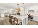 Open kitchen featuring large island with seating, white cabinets, stainless appliances, and view into the living room at 9615 Sedona Hills Ct, Las Vegas, NV 89147