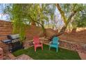 Cozy backyard area with artificial turf, brick wall and a barbecue grill perfect for outdoor entertaining at 11074 Caramel Crest Ct, Las Vegas, NV 89135