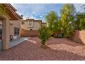 Expansive backyard with gravel landscaping, trees, brick walls providing a private and serene outdoor space at 11074 Caramel Crest Ct, Las Vegas, NV 89135