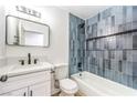 Stylish bathroom with blue tiled shower and tub, white vanity, and modern fixtures at 1116 E Owens Ave, North Las Vegas, NV 89030