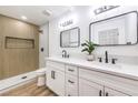 Modern bathroom featuring dual sinks, sleek fixtures, and a tiled walk-in shower with a decorative niche at 1116 E Owens Ave, North Las Vegas, NV 89030