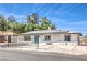 Charming single-story home with solar panels, a fenced yard, and a bright teal front door at 1116 E Owens Ave, North Las Vegas, NV 89030