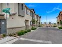 A well-maintained neighborhood street featuring townhomes with manicured landscaping and clear street signage at 12107 Frost Lime Rd # 1, Las Vegas, NV 89183