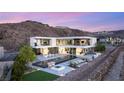Stunning modern home with an infinity pool, fire pit, outdoor seating, and mountain views at 13 Rockstream Dr, Henderson, NV 89012