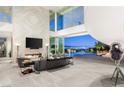 Modern living room boasting a fireplace, city views, and an open transition to the outdoor pool area at 13 Rockstream Dr, Henderson, NV 89012