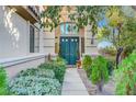 Elegant front entrance featuring a double door framed by an archway, lush greenery, and a stone walkway at 1353 Volturno Way, Henderson, NV 89052