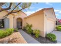 Inviting front entrance with arched doorway, desert landscaping, and two car garage at 1781 Cypress Lake Ct, Henderson, NV 89012