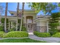 Charming home with stone accents, manicured landscaping and decorative trees surrounding the entrance at 2008 Winter Wind St, Las Vegas, NV 89134