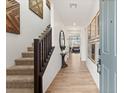 Inviting foyer with wood-look tile flooring, staircase, and decorative wall art at 2624 Stanhurst Ave, North Las Vegas, NV 89081